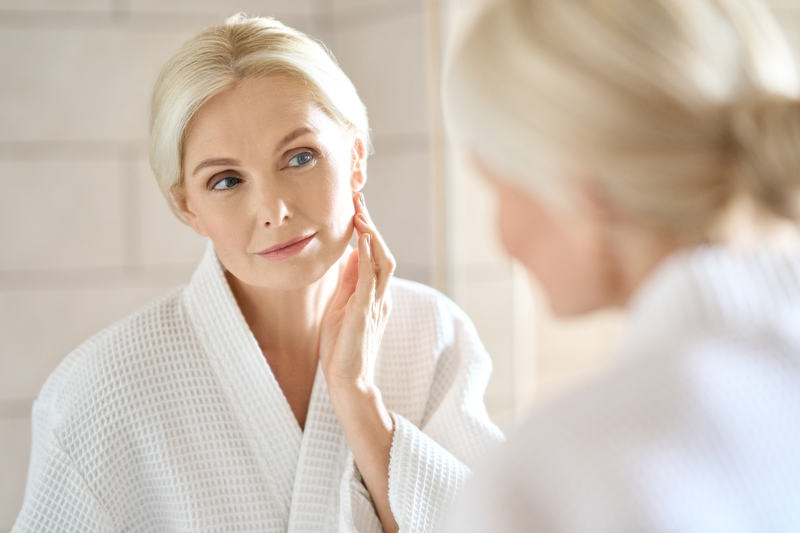 woman rubbing lotion on face