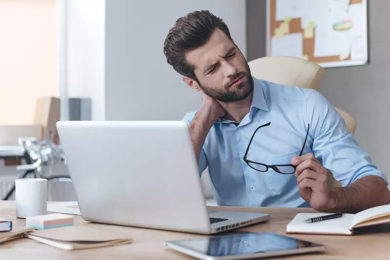 man at table with neck pain