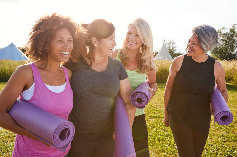 smiling women with yoga mats