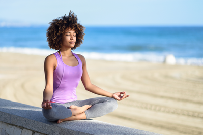 woman in a meditation pose at the beach