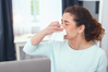 woman with nasal congestion blowing nose into a tissue