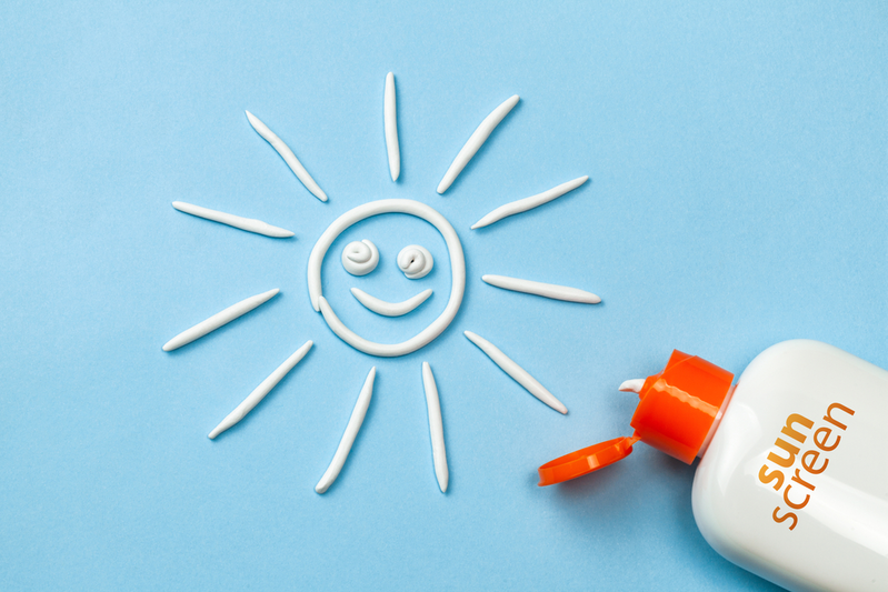 smiling sun made from sunscreen next to bottle labeled Sunscreen