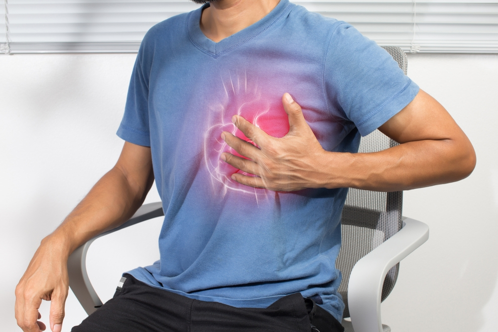 man holding chest in pain due to heart attack