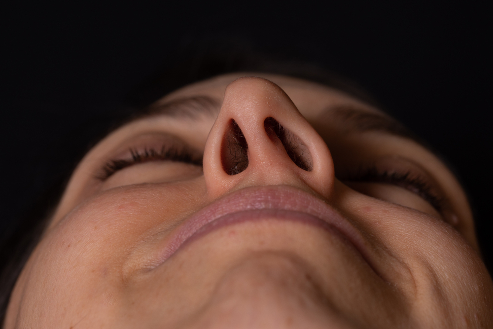 looking up at woman's nose with deviated septum