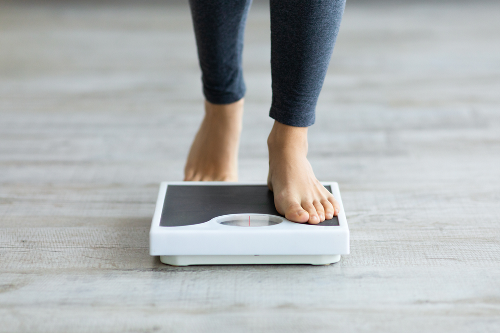 female feet stepping on floor scale