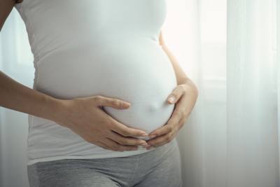 close up of woman holding her pregnant belly