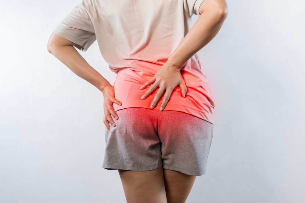 woman holding backside with hemorrhoid pain